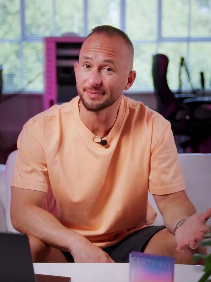 Maciej Konarzewski talking to camera in a peach T-shirt